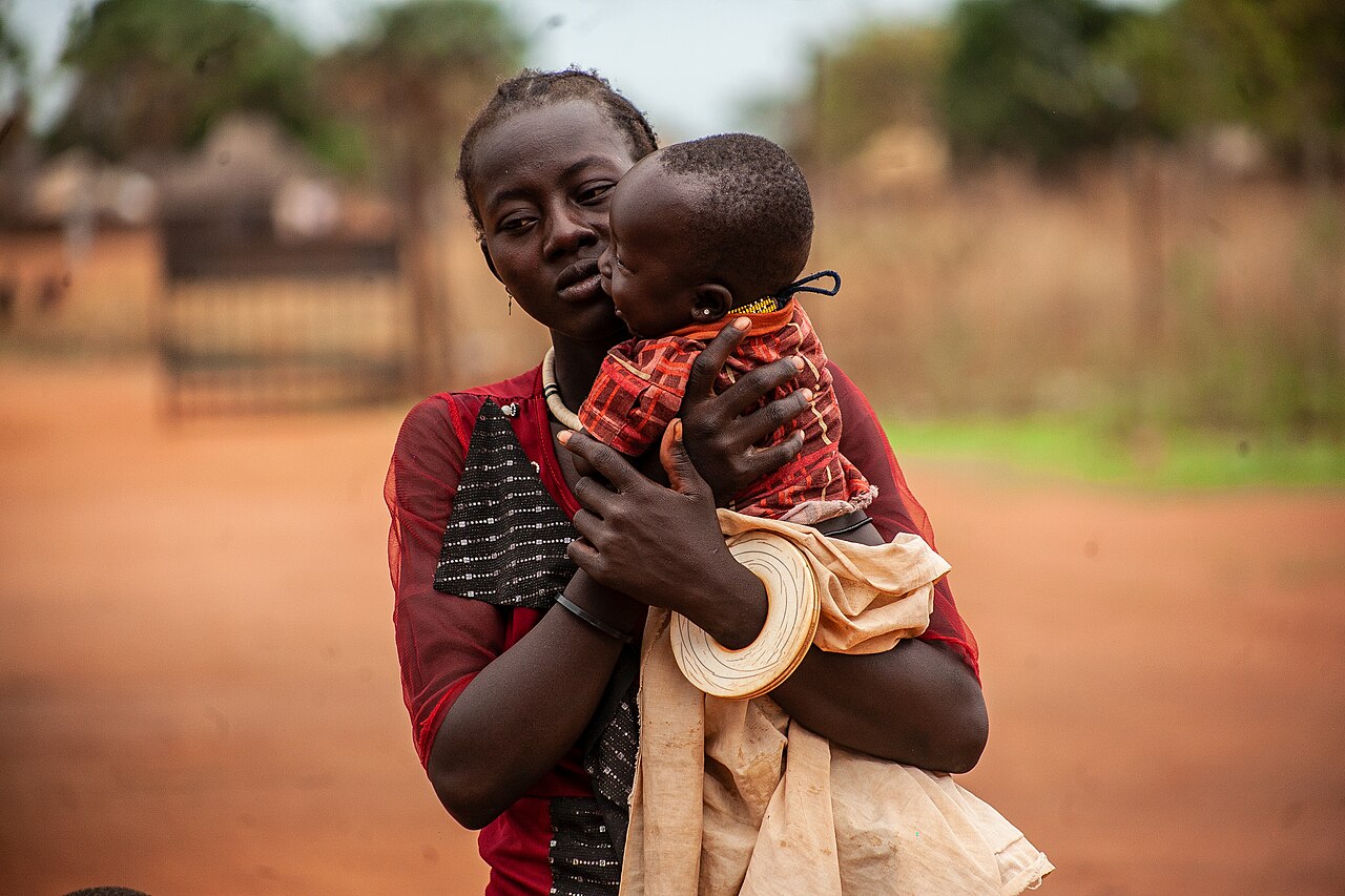 A mother holding her baby as they wait for treatment at a health facility in South Sudan