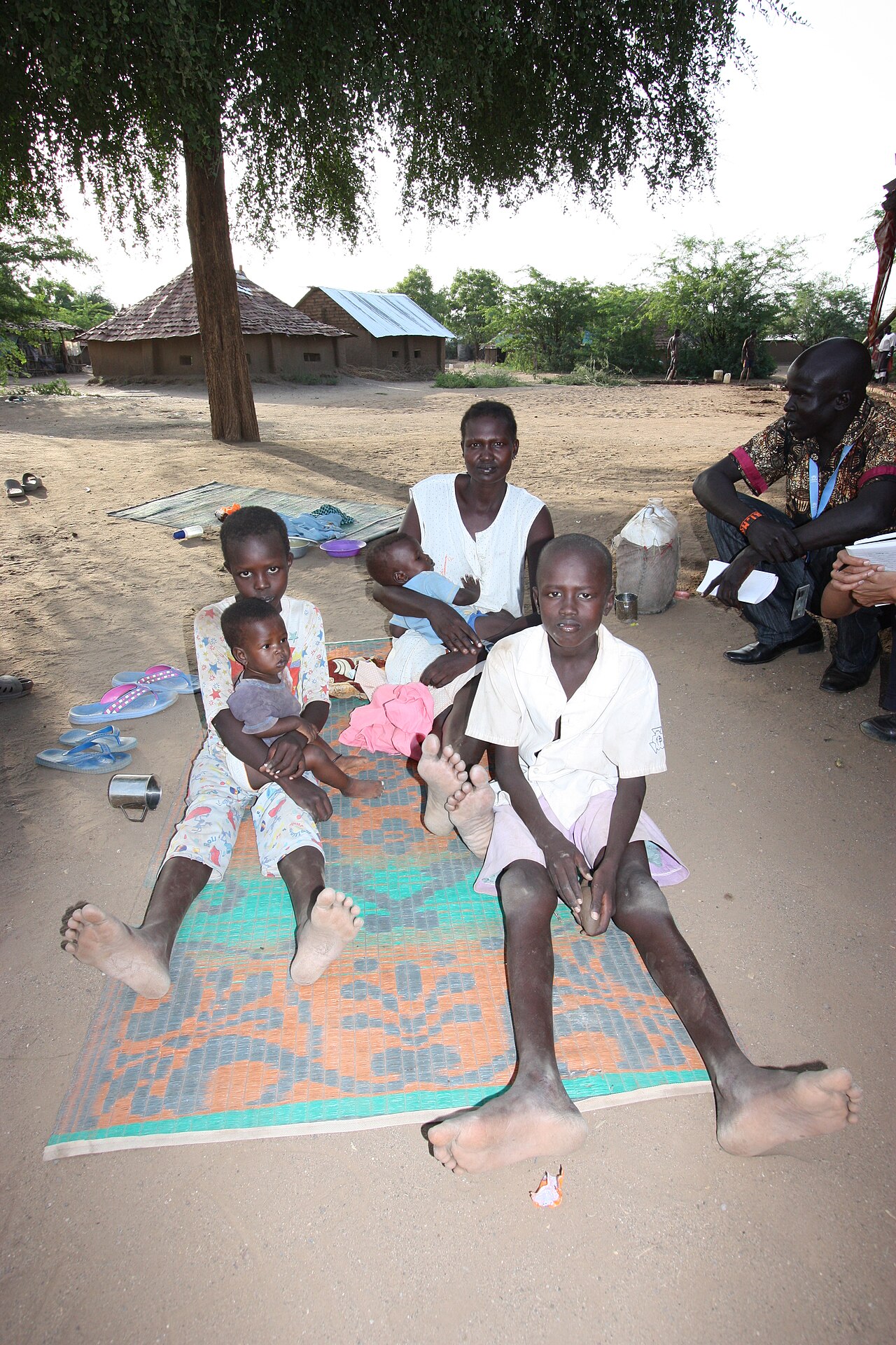A family seated under a tree in Jonglei, South Sudan, during a visit by aid workers